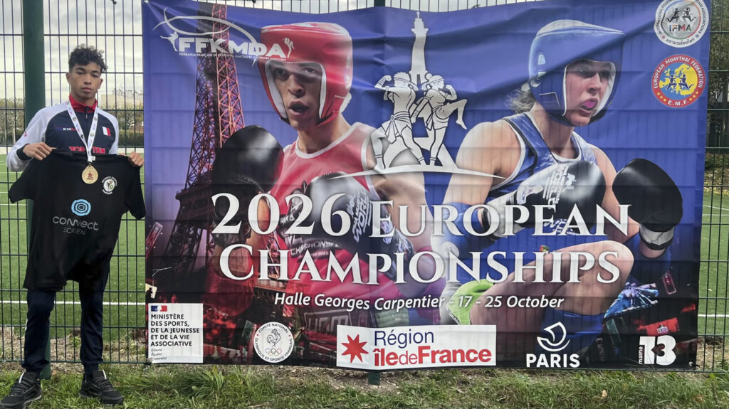 Kaïs Piduch, médaillé d’or, tenant un maillot Connect Screen devant la bannière des Championnats d’Europe 2026 à Paris